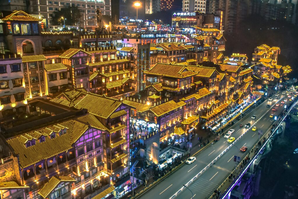 Stunning night view of illuminated traditional Chinese architecture in Chongqing's bustling cityscape.